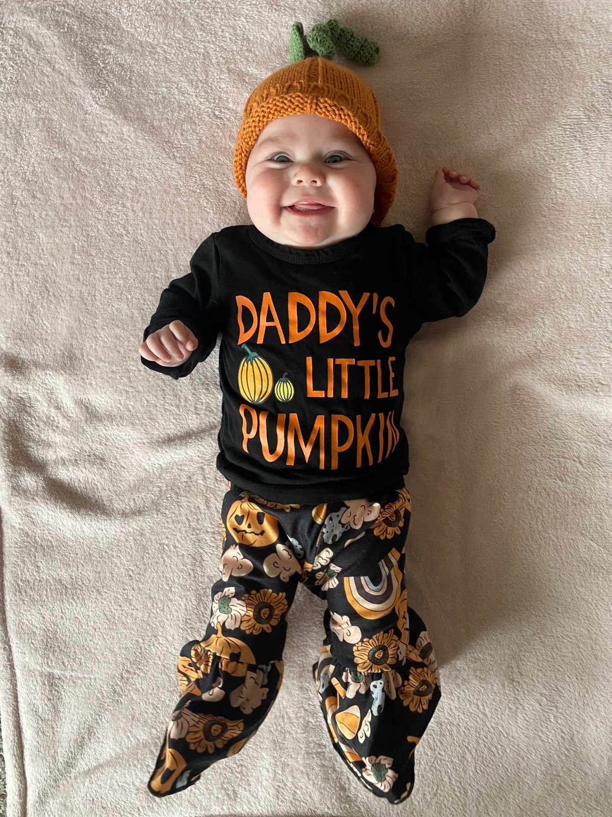 Baby Vivian in a knitted pumpkin hat and a Daddy's Little Pumpkin outfit
